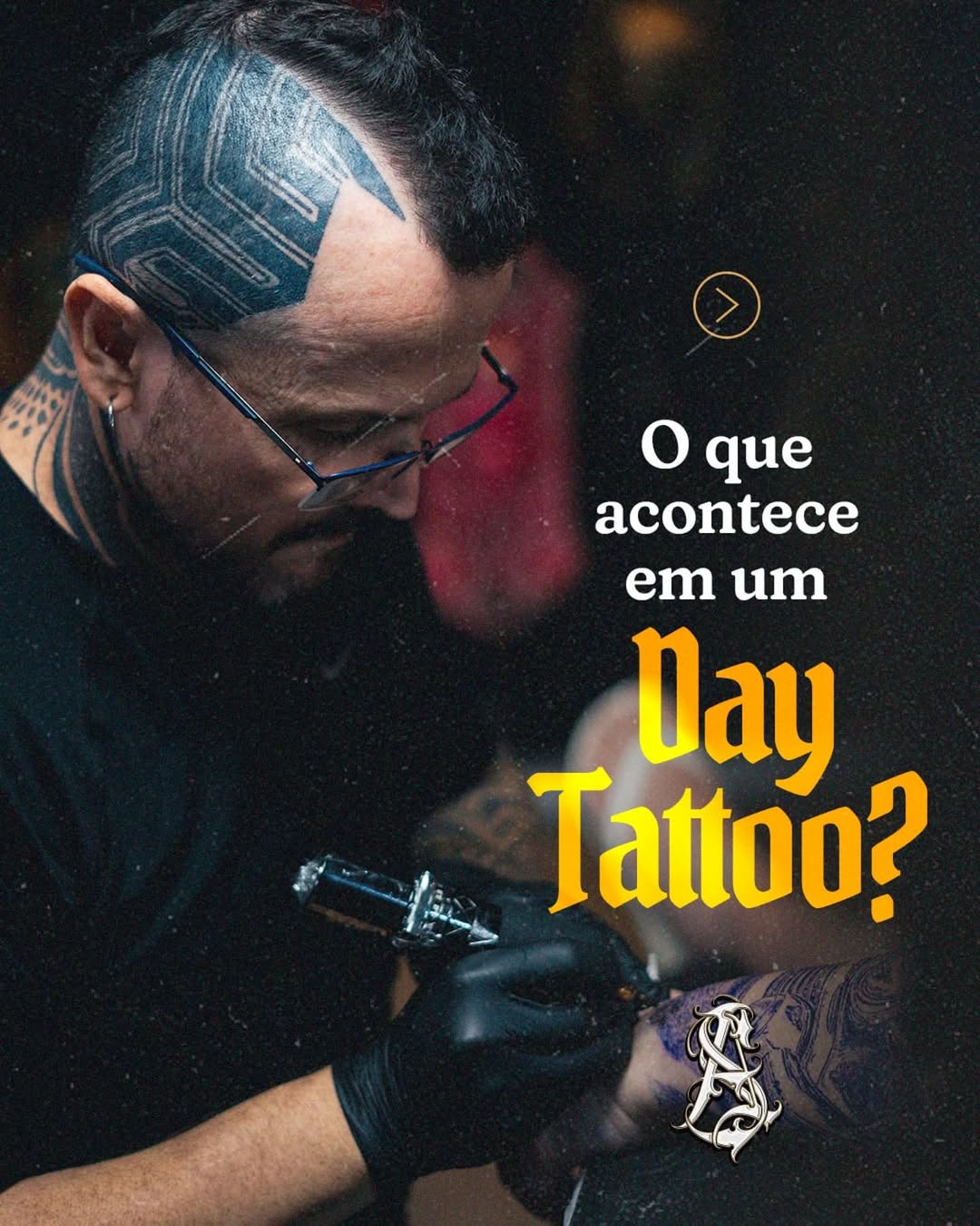 Tattoo artist with glasses and geometric head tattoo applies ink to client's arm during tattooing session, captured in black and grey.