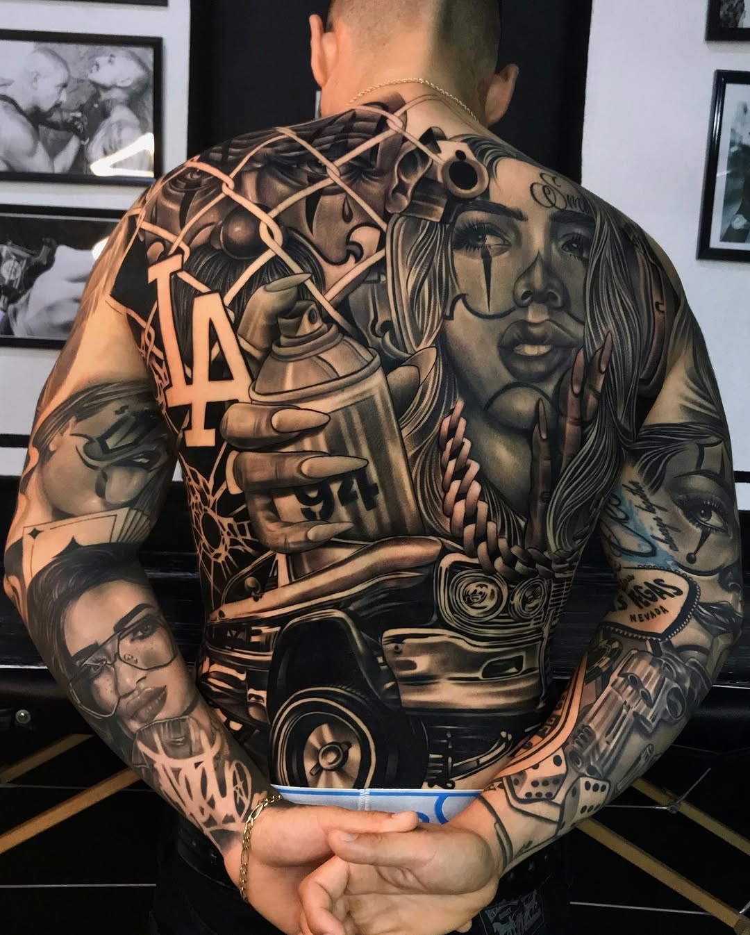 Black and grey back and arm tattoo featuring a woman's face, spray paint can, car, chain-link fence, and LA lettering.