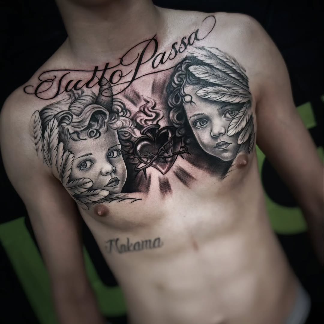 Two detailed portrait faces with ornamental wing and floral elements on chest, connected by a heart design, in black and grey ink.