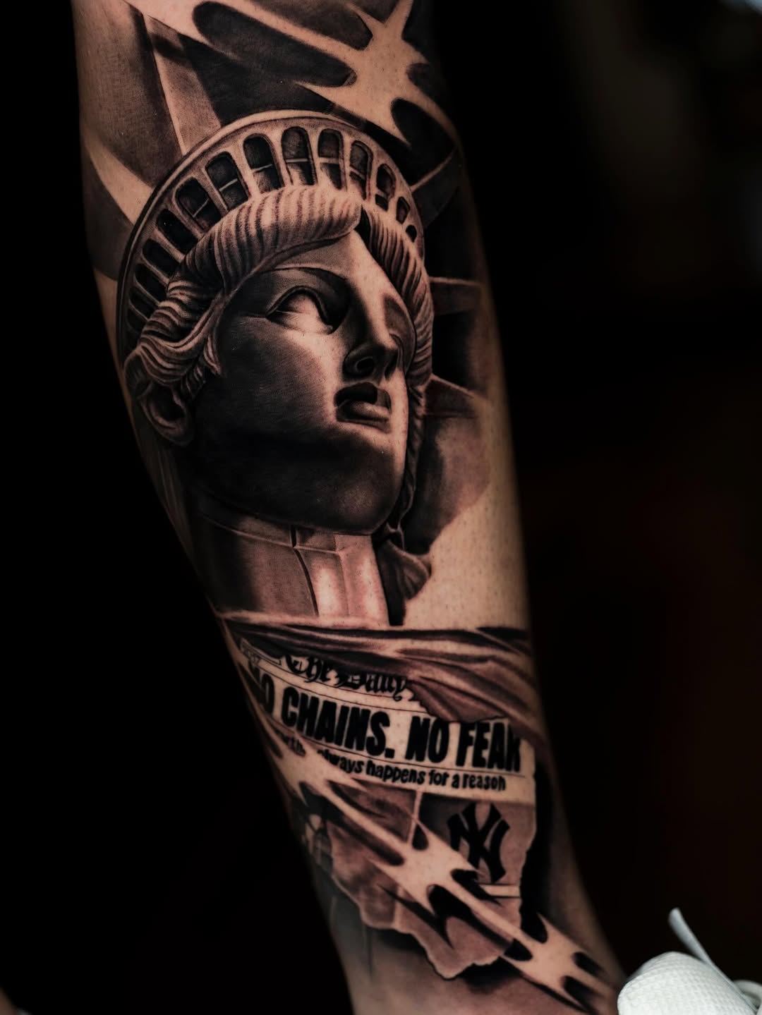 Statue of Liberty profile with crown and torch, banner text below, on leg with dramatic shading in black and grey.