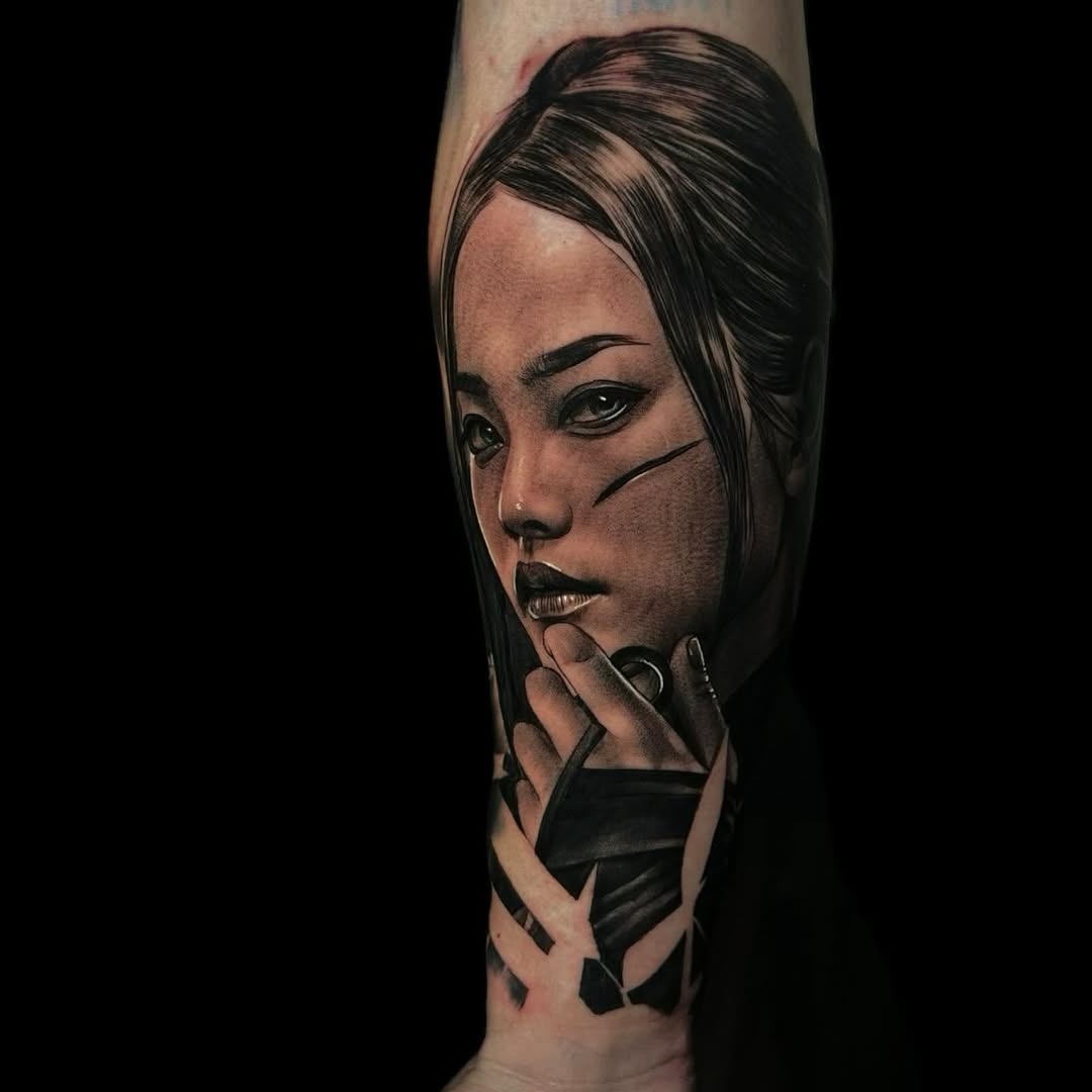 Portrait tattoo of a woman with long dark hair and hand near face, rendered in black and grey shading on the leg.