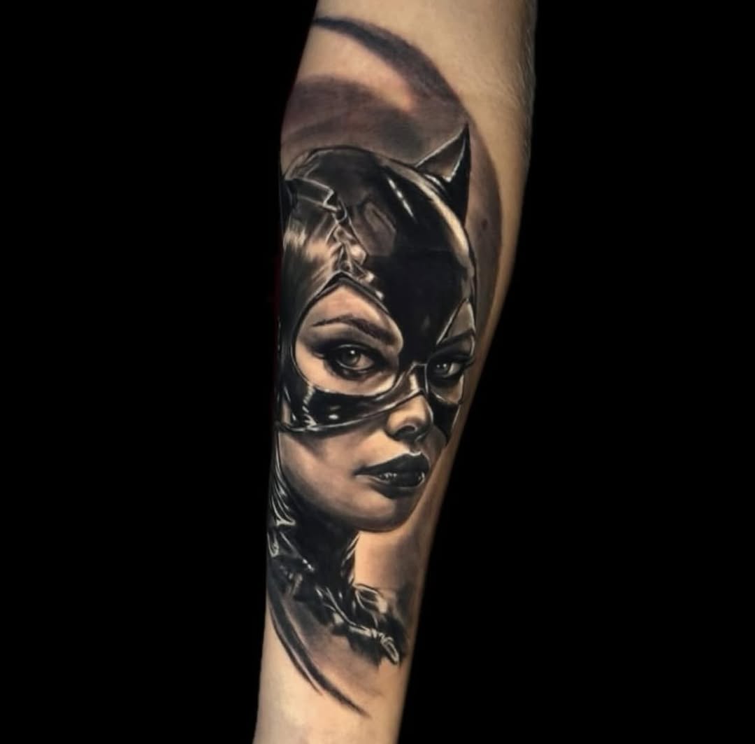 Woman's face wearing a cat-eye mask with pointed ears, rendered in black and grey with smooth shading on forearm.