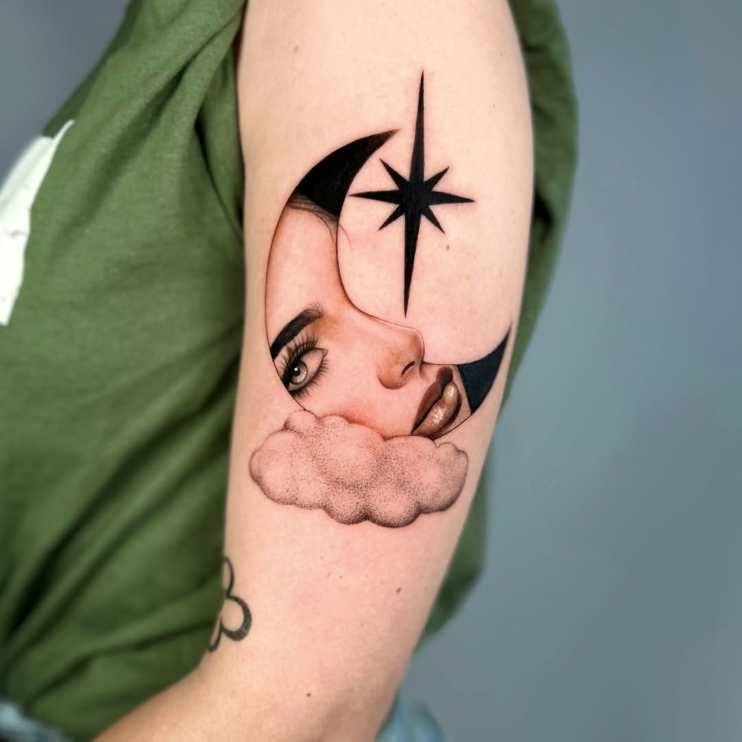 Woman's arm tattoo featuring a face in profile resting on a cloud with a crescent moon and star above, rendered in black and grey.