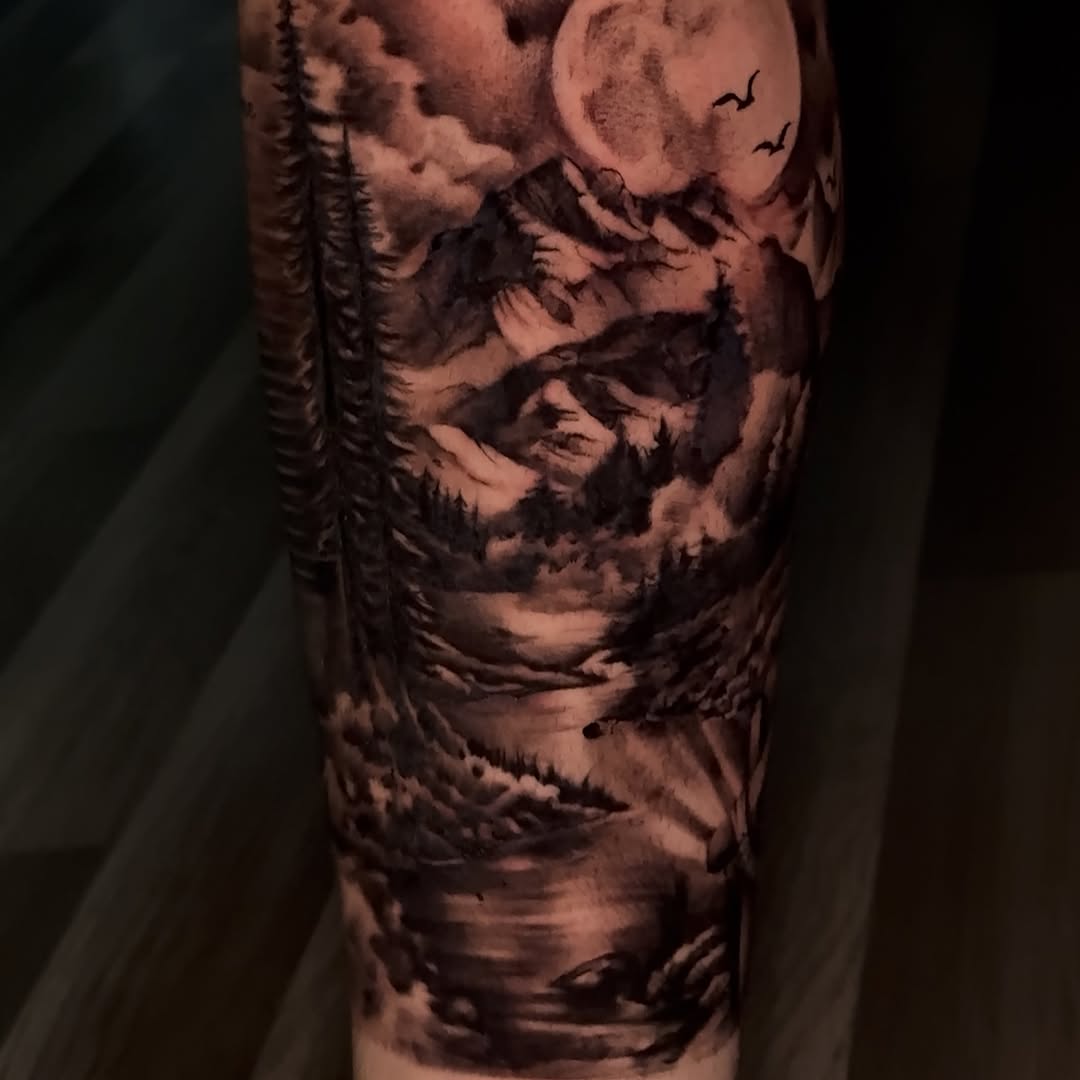Mountain landscape with forest silhouettes and birds in flight, rendered in black and grey on the arm with smooth shading gradients.