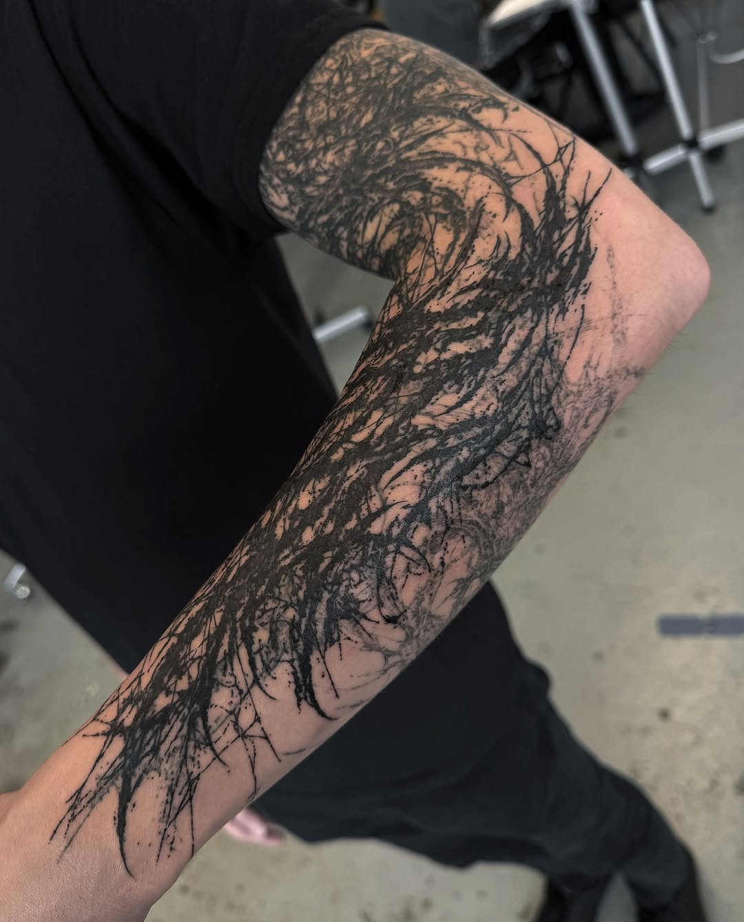 Full-length arm sleeve featuring intricate black tree branches and root systems with organic, flowing linework and splatter details.