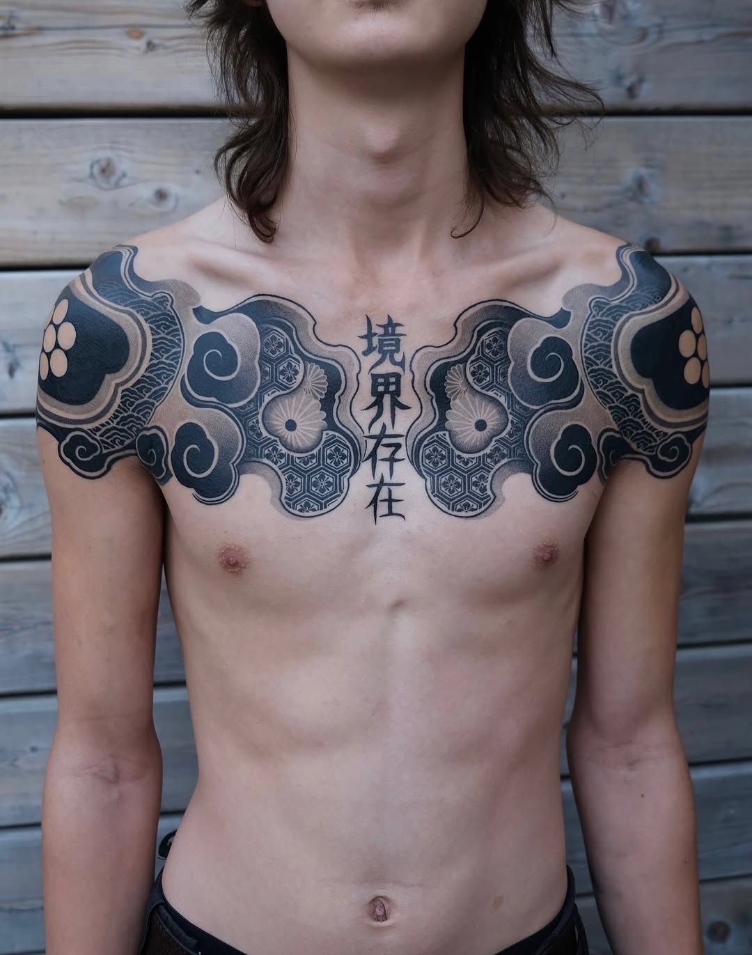 Symmetrical chest piece featuring ornamental geometric patterns, floral mandalas, and Japanese characters in black and grey ink.
