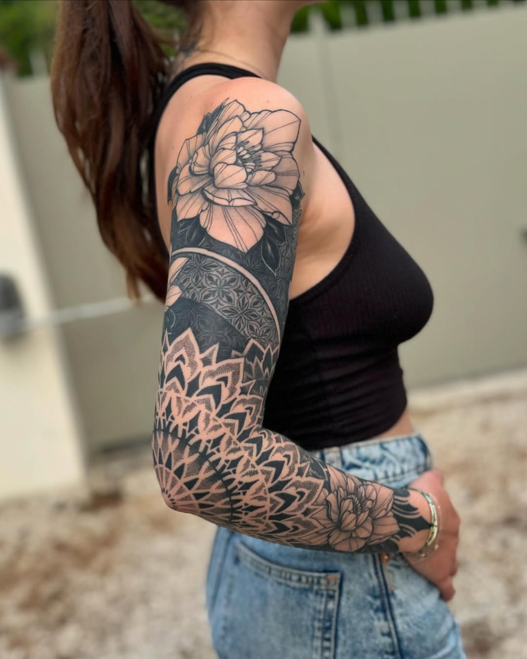 Full arm sleeve featuring a detailed sunflower at shoulder, ornamental mandala band, and geometric stippled patterns extending to wrist.
