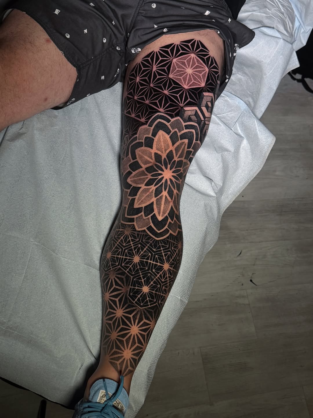 Full leg sleeve featuring geometric mandalas and sacred geometry patterns in orange and black linework.