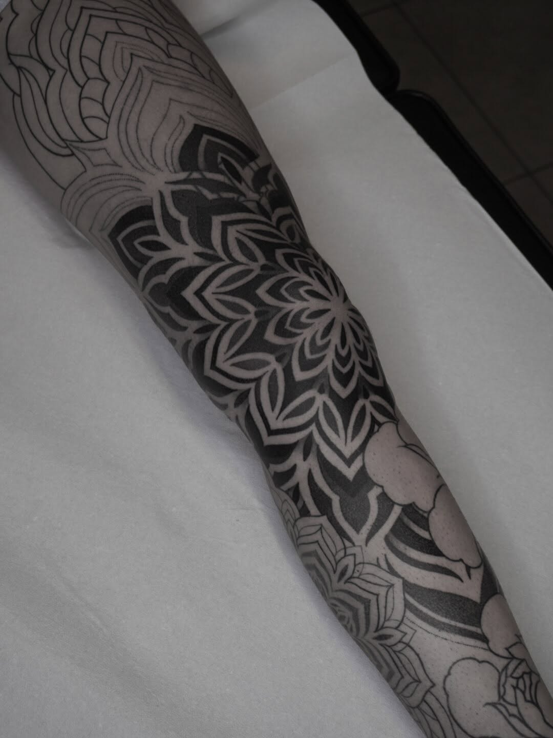 Mandala and ornamental geometric patterns with symmetrical linework covering the forearm and extending to the wrist.