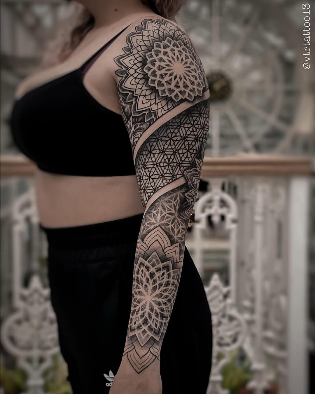 Full sleeve mandala and geometric ornamental tattoo with symmetrical linework and dotwork patterns extending from shoulder to wrist.